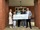A group of six people stands on a brick porch holding an oversized check. The check displays the ExxonMobil logo and is made out for $5,000.