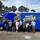 A group of nine adults stands in front of a bright blue “Mobile STEM” van.