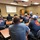 A group of Lafayette County First Responders sits at long tables in a classroom-style room, listening to a speaker standing at the front.