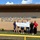 A group of seven people stands in front of a brick building with a large “Boys & Girls Club of Magnolia” sign.